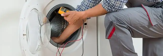 Dryer repair technician inspecting and repairing a clothes dryer in Rochester, NY