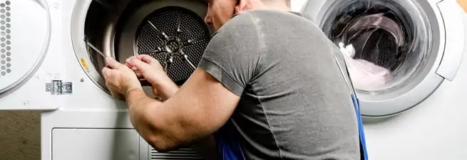 Dryer repair technician fixing a clothes dryer drum in Rochester, NY