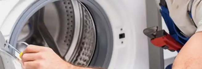 Appliance technician repairing a clothes dryer drum and internal parts in Rochester, NY