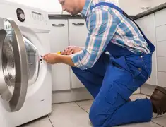 Washing machine repair technician servicing a front-load washer in Rochester, NY
