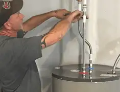 Water heater repair technician tightening supply line connections in Rochester, NY